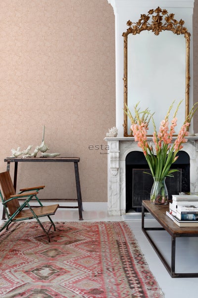 Dekoratives Wohnzimmer mit gemusterter Tapete, antikem Spiegel über einem Kamin, Teppich und Beistelltisch