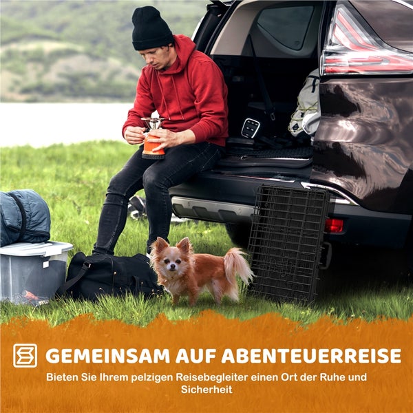 Mann bereitet Campingkocher am Kofferraum vor, mit Hund und Transportbox