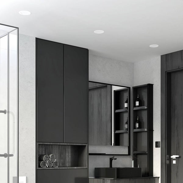 Modernes Badezimmer mit schwarzen Badmöbeln, Einbaustrahlern in der Decke, einem schwarzen Waschbecken und einem großen Spiegel.