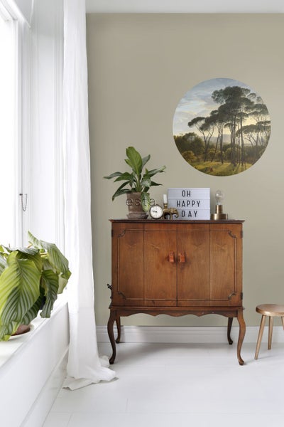 Dekoratives Interieur mit Kommode, Zimmerpflanzen und Wandbild