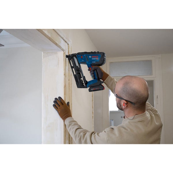 Handwerker verwendet einen Akku-Nagler von Bosch an einem Türrahmen