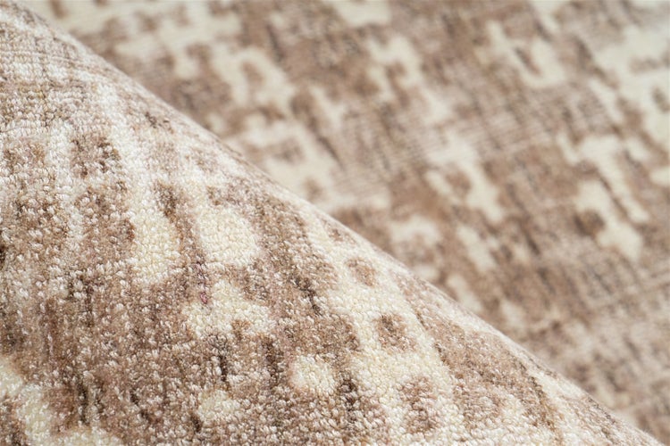 Detailaufnahme eines gewebten Teppichs mit abstraktem Muster und weicher Textur.