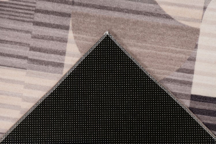 Detailansicht eines Teppichs mit geometrischem Muster und rutschfester Unterseite mit Noppen.