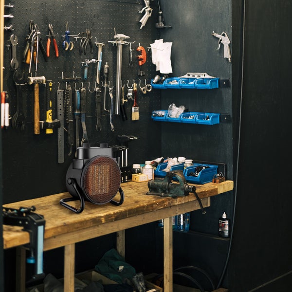 Werkstattszene mit Heizlüfter auf einer Werkbank und Werkzeugen an der Wand