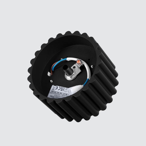 Schwarzer, geriffelter Lampensockel aus Metall mit sichtbarer Innenverkabelung und technischem Aufkleber.