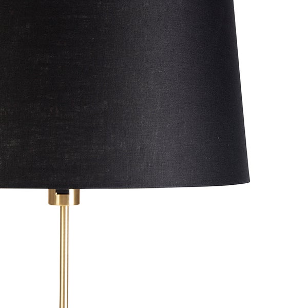 Detailansicht einer Stehlampe mit schwarzem Lampenschirm und goldenem Lampenfuß