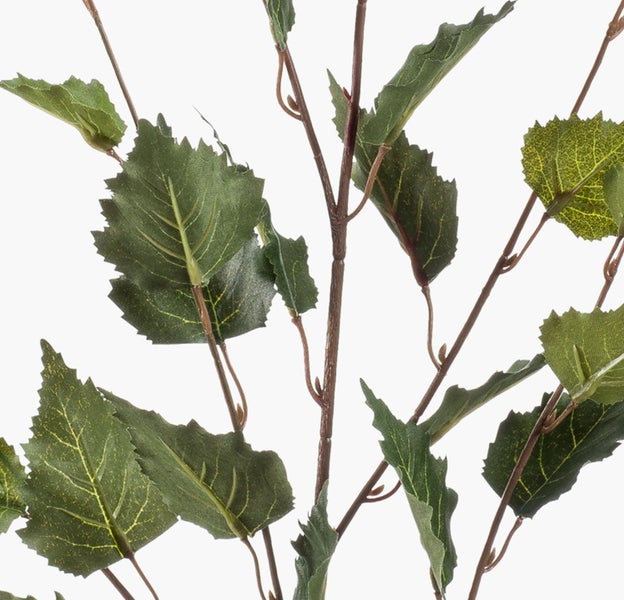 Künstliche Hortensie in Weiß mit grünen Blättern in einem geflochtenen Korb.