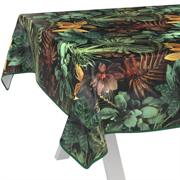 Tischdecke mit tropischem Pflanzenmuster aus Blättern und Blüten, über eine Tischecke drapiert.