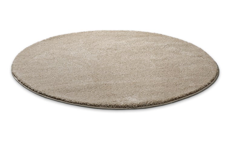 Runder beigefarbener Teppich mit weichem Flor und geketteltem Rand.