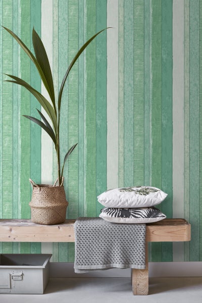 Gestaltungsidee mit einer Holzbank, Kissen, einer Zimmerpflanze und einer Tapete mit Holzplankenmuster