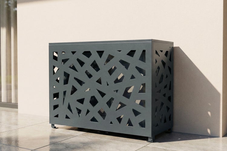 Metall-Abdeckung für Klimaanlage oder Wärmepumpe mit geometrischem Laser-Cut-Muster, auf einer Terrasse an einer Hauswand stehend.