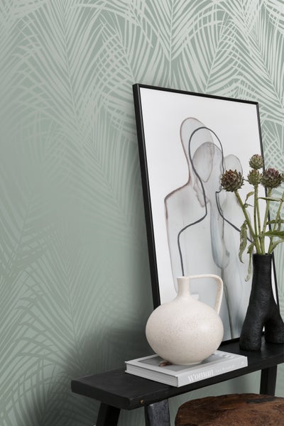 Wandgestaltung mit floraler Tapete, dekoriert mit Kunstbildern und Vasen auf einer Konsole