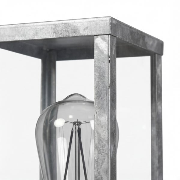 Nahaufnahme einer industriellen Tischleuchte mit sichtbarem Leuchtmittel und verzinktem Metallrahmen.