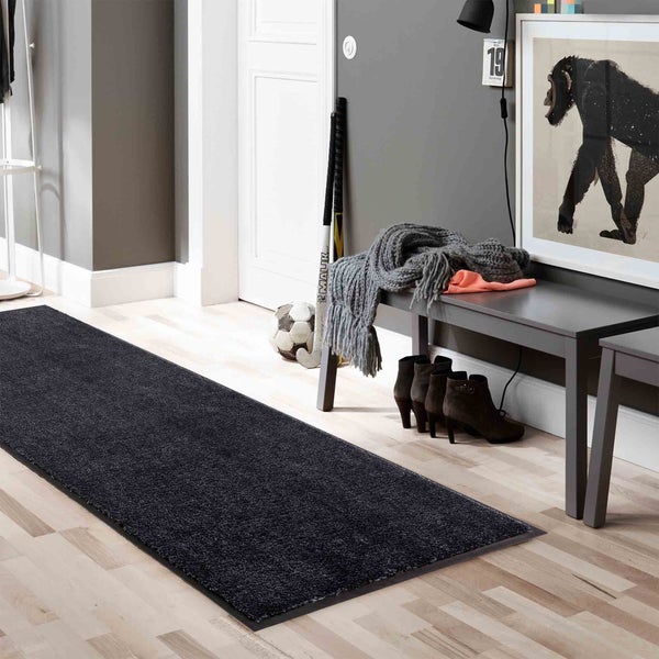 Szene mit einem langen, dunklen Teppich im Flur, kombiniert mit einer Bank, Accessoires und Sportartikeln