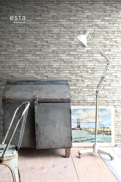 Wohnszene mit Backsteintapete, Metallschrank, Stehlampe und Bild