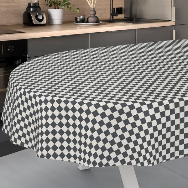 Runde, karierte Tischdecke auf einem runden Tisch in einer modernen, organisierten Küche mit Holzarbeitsplatte.