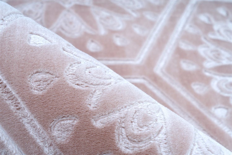 Detailansicht eines weichen Kurzflorteppichs mit geprägtem floralem Muster.