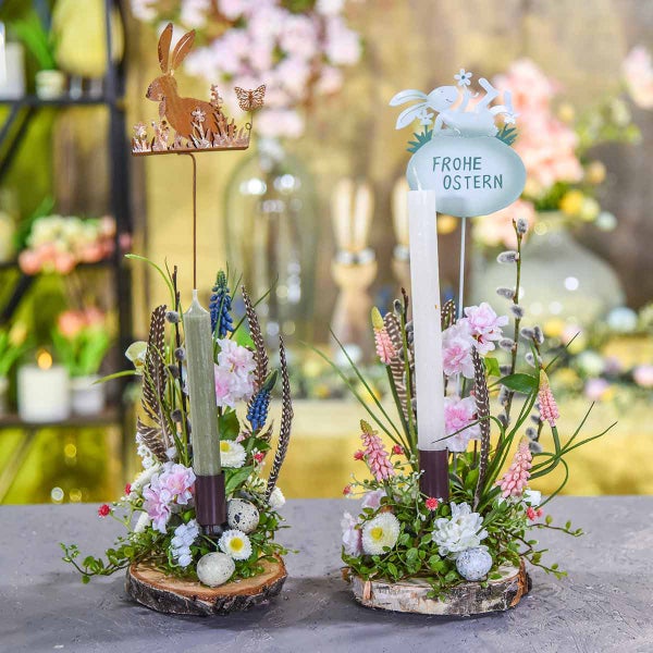 Zwei Osterdekorationen mit Kerzen, Blumen und Hasenfiguren auf Holzböden.