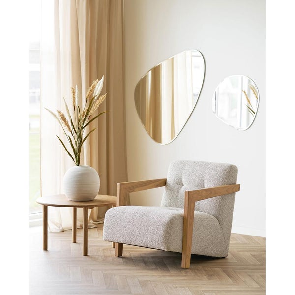 Wohnzimmer-Szene mit Sessel, Beistelltisch, Vase mit Pflanzen und zwei asymmetrischen Spiegeln