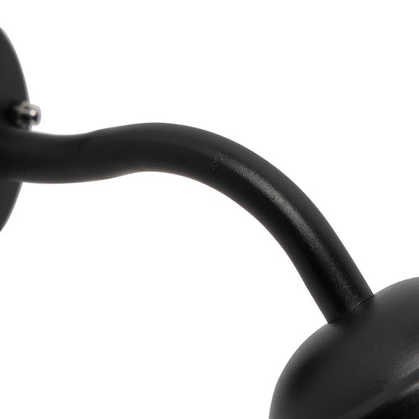 Gebogener Metallarm einer schwarzen Wandleuchte.