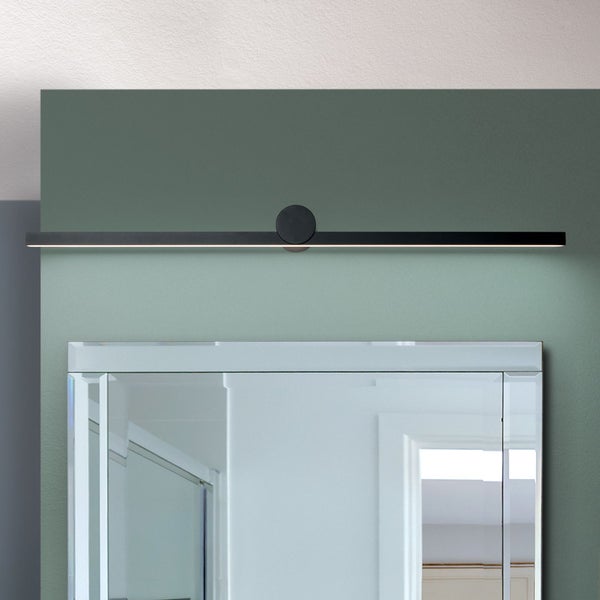Moderne LED Spiegelleuchte in minimalistischem Design über einem Wandspiegel montiert.