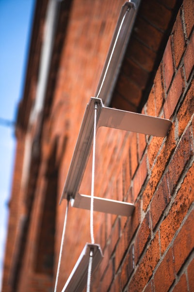 Wäscheleine mit Metallhalterung an einer Ziegelwand