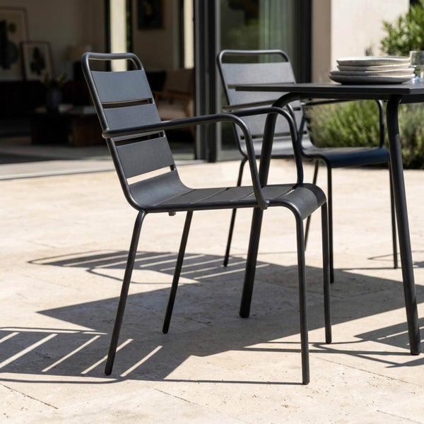 Moderner Gartenstuhl aus Metall in Anthrazit mit Armlehnen, platziert auf einer Terrasse neben einem passenden Gartentisch.