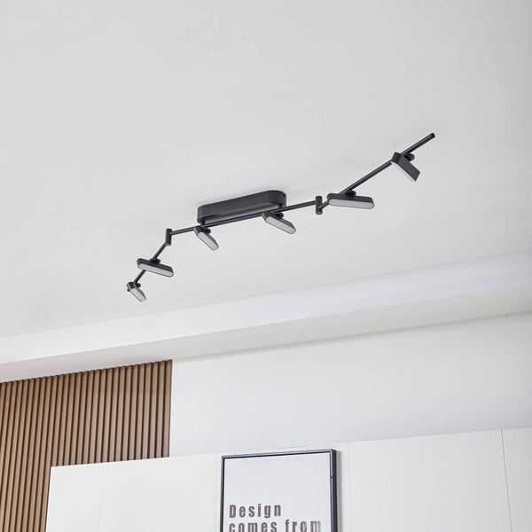 Moderne, sechsflammige Deckenleuchte in Schwarz mit verstellbaren LED-Spots und beweglichen Gelenkarmen an einer weißen Zimmerdecke.