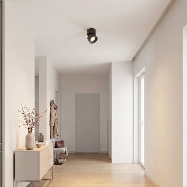 Moderne Deckenleuchte als runder Aufbaustrahler in einem hellen Flur mit Holzboden und minimalistischer Einrichtung.