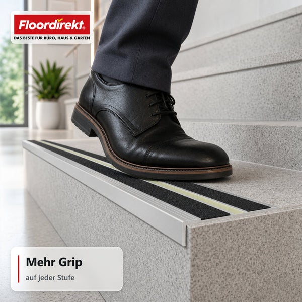 Treppenkantenprofil mit Antirutschbelag auf einer Steintreppe mit Fuß im Lederschuh und Floordirekt Logo