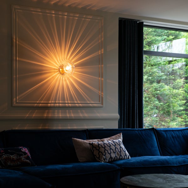 Wohnzimmer mit Wandleuchte, Sofa und Fenster