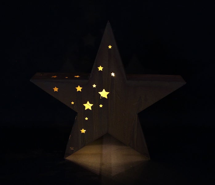 Beleuchteter Stern aus Metall mit ausgestanzten Sternmotiven für weihnachtliche Dekoration