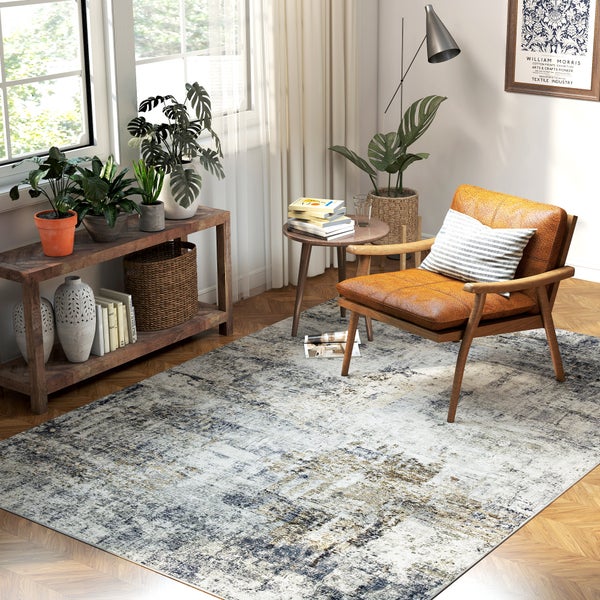 Modernes Wohnzimmer mit abstrakt gemustertem Teppich, einem Ledersessel, einem Beistelltisch aus Holz und Zimmerpflanzen vor einem Fenster.