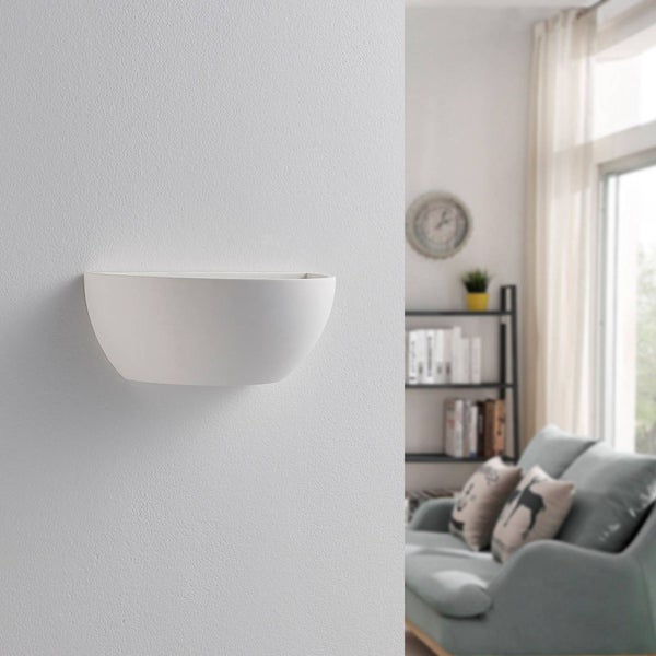 Halbrunde Wandleuchte aus Gips an einer strukturierten Wand in einem hellen Wohnzimmer.