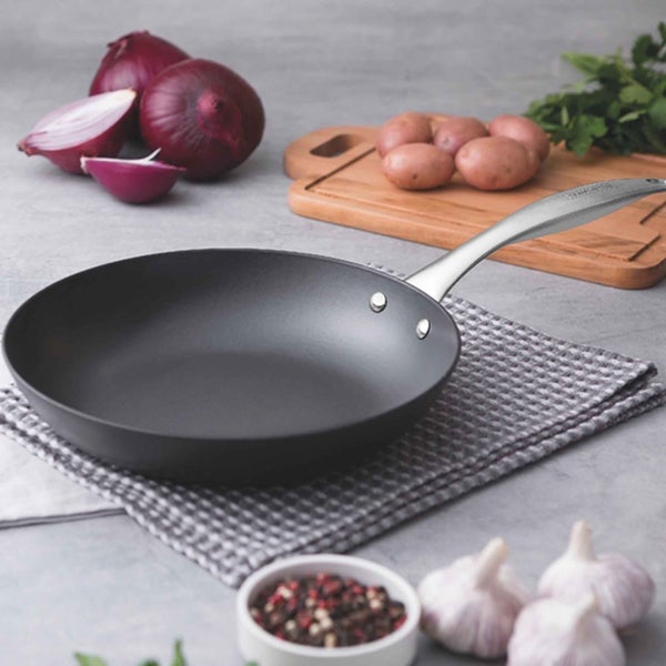 Bratpfanne mit Zutaten wie Zwiebeln, Kartoffeln und Knoblauch