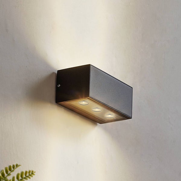 Rechteckige LED Wandleuchte in Anthrazit mit drei Lichtquellen an der Unterseite, die Lichtkegel nach oben und unten an eine Wand wirft.