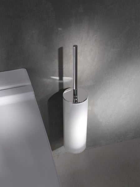 Wandhängende Keuco Toilettenbürstengarnitur mit weißem Behälter und verchromtem Griff neben einer Toilette in einem modernen Badezimmer.
