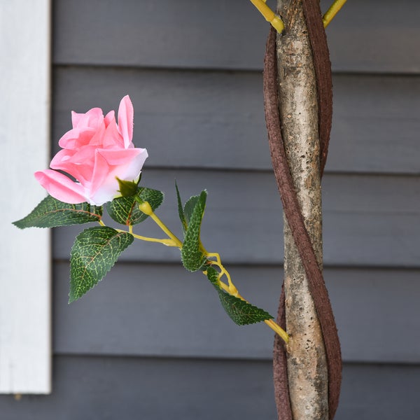 Künstlicher Rosenbaum mit rosa Blüte und gewundenem Stamm