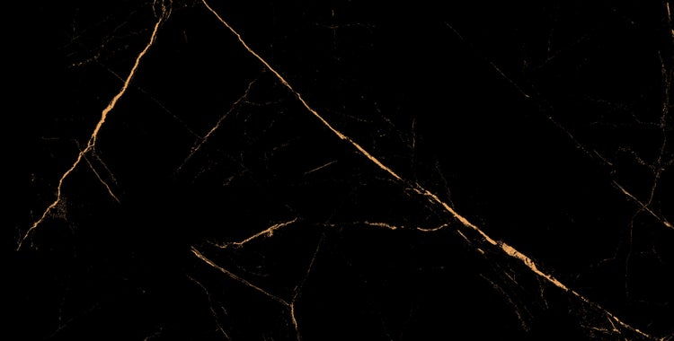 Nahaufnahme einer schwarzen Fliese mit goldenen Adern.