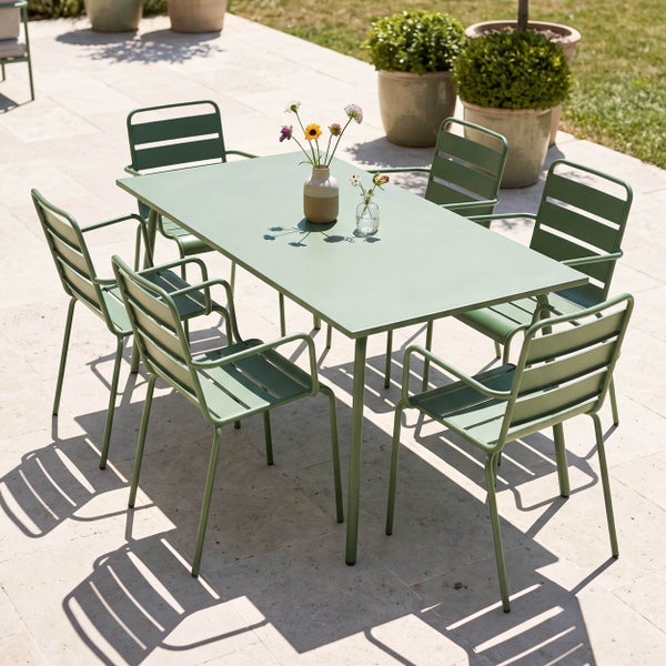 Grünes Gartenmöbel-Set mit einem rechteckigen Metalltisch und sechs Metall-Armlehnenstühlen auf einer hellen Steinterrasse.