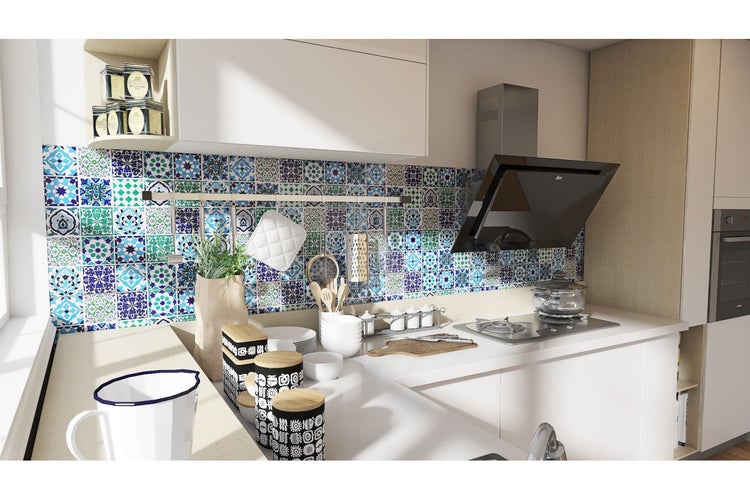 Moderne Küche mit Fliesenspiegel im Patchwork Design, Dunstabzugshaube und Kochutensilien.