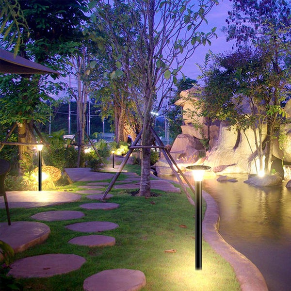 Beleuchteter Garten mit Rasen, Bäumen, Teich und Gartenleuchten