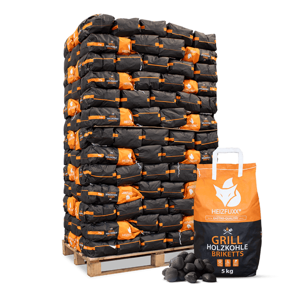Heizfuxx Grill Holzkohle Briketts, 5 Kilogramm Beutel auf einer Palette gestapelt mit einem Beutel und losen Briketts davor.
