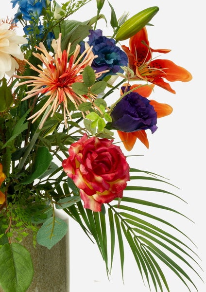 Künstlicher Blumenstrauß mit Dahlien, Rittersporn und Palmblättern für die Dekoration.