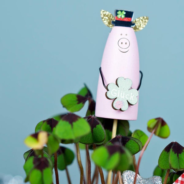 Dekoration mit Glücksschwein, vierblättrigem Klee und der Aufschrift Glück