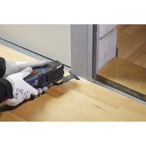 Oszillierendes Elektrowerkzeug im Einsatz zum Schneiden eines Holzbodens