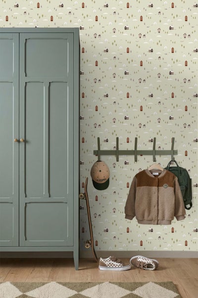 Tapete mit Häusermuster in einem Kinderzimmer mit grünem Schrank, Garderobenleiste und Skateboard.