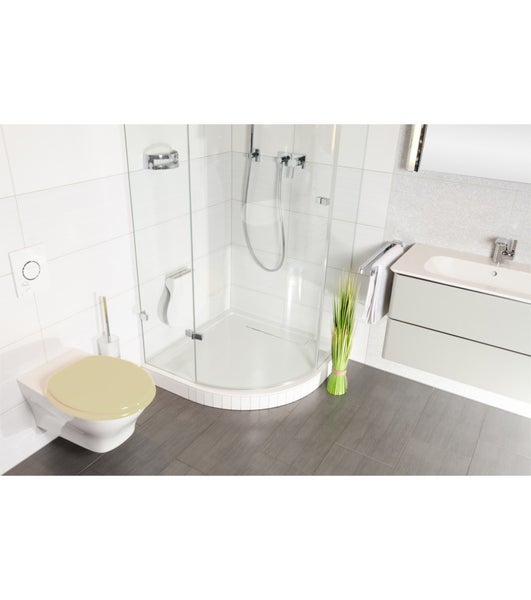 Modernes Badezimmer mit wandhängendem WC, beigem WC-Sitz, gläserner Rundduschkabine, Waschtischunterschrank und grauen Bodenfliesen.