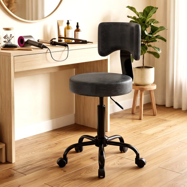 Hocker mit Rückenlehne und Rollen vor einem Schminktisch in einem hellen, modern eingerichteten Raum.