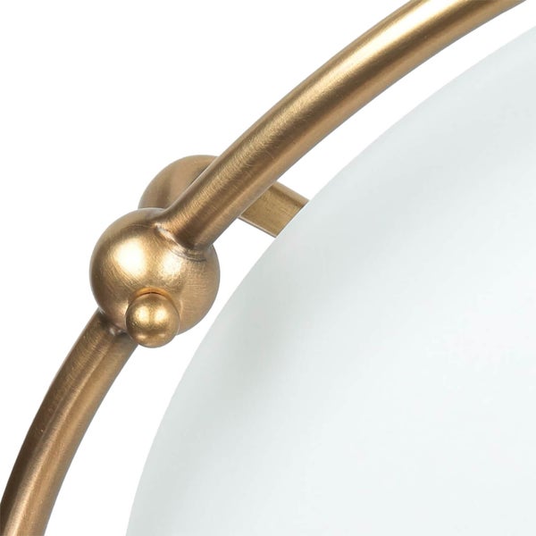 Detail einer Lampe mit runder, weißer Glasabdeckung und goldfarbenem Metallgestell